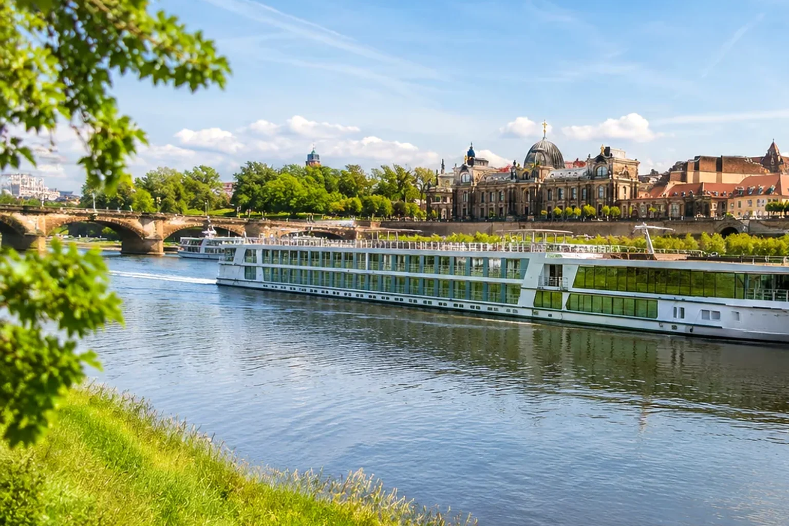 Sonnige Flussreise mit modernem Schiff vor einer historischen Uferstadt